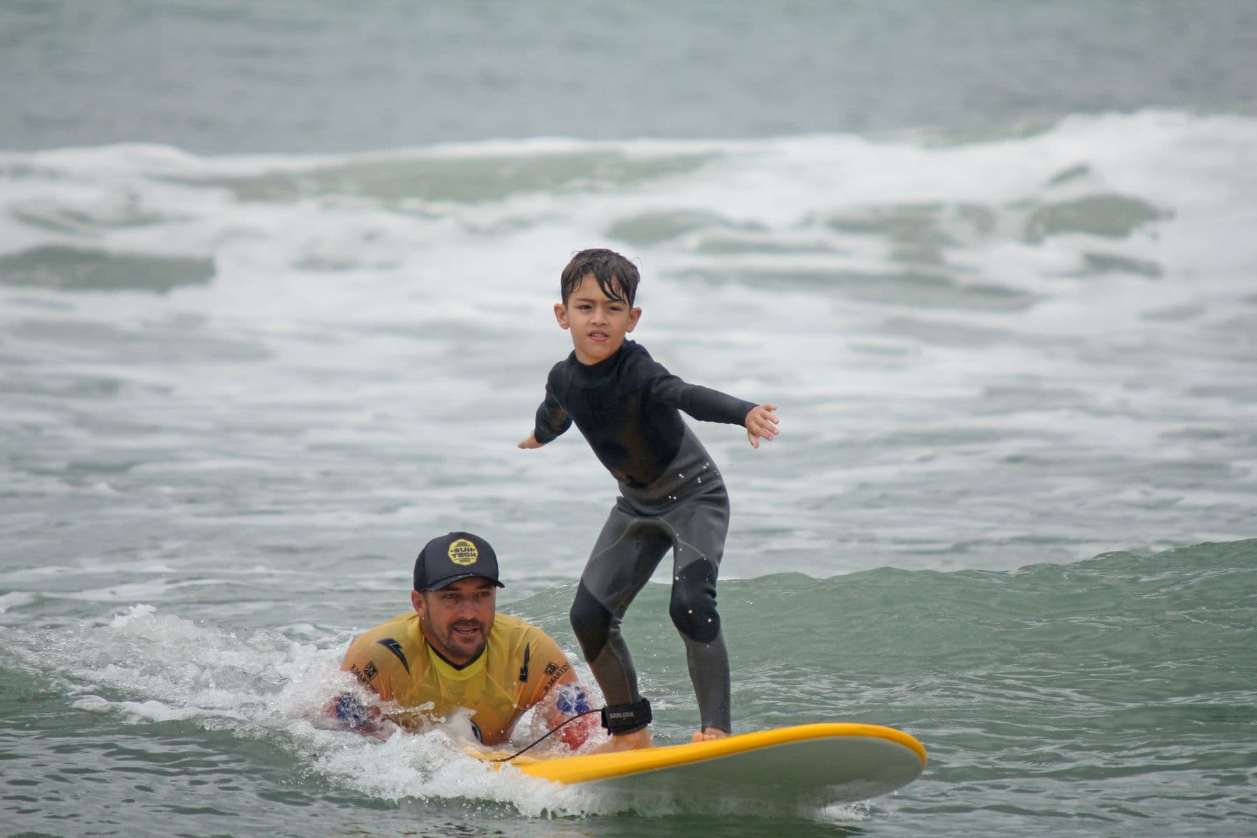 Criança surfando na aula Kids