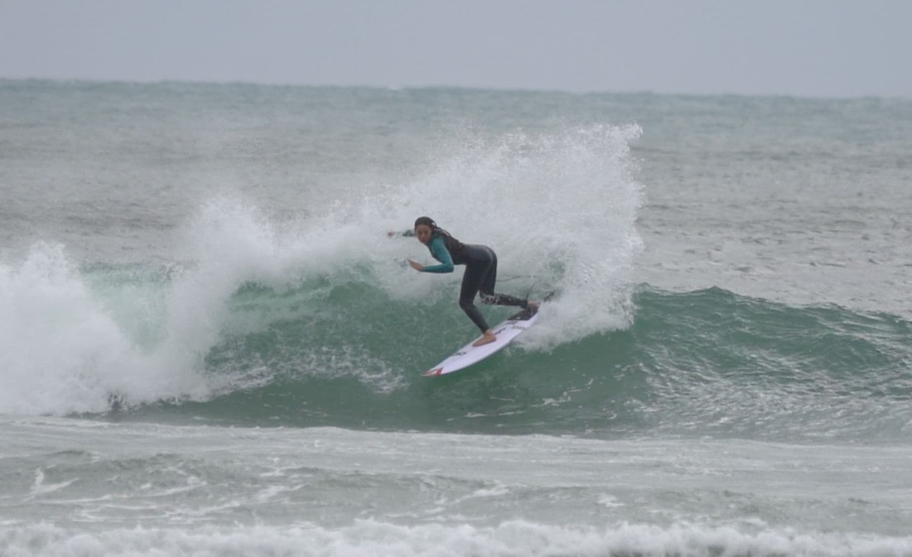 Surfista em manobra com spray